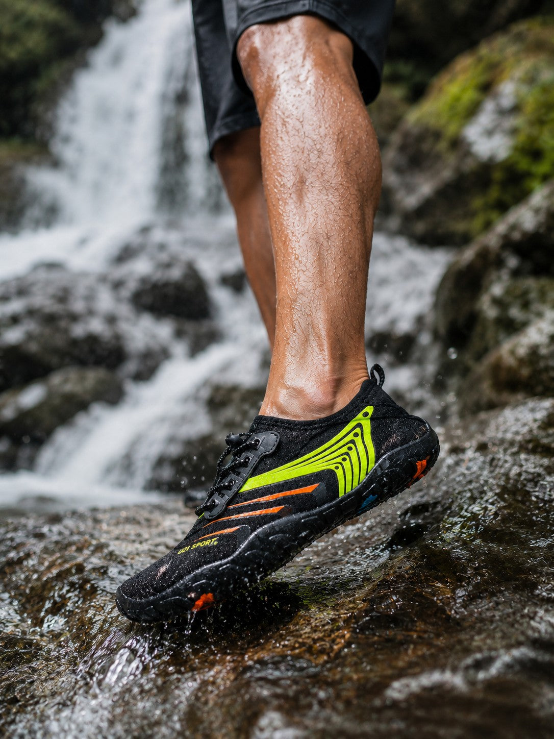 Zapato acuático uzi sport guadalajara Nauspeed negro con detalles verde neón y naranja en entorno de cascada