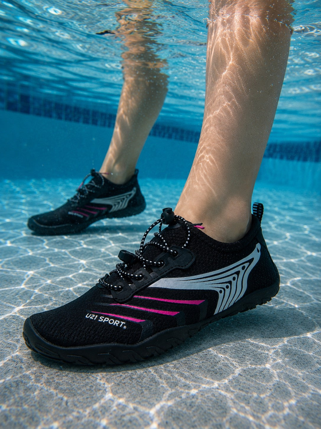 Zapato acuático uzi sport guadalajara Nauspeed negro con detalles rosas sumergido en agua de piscina