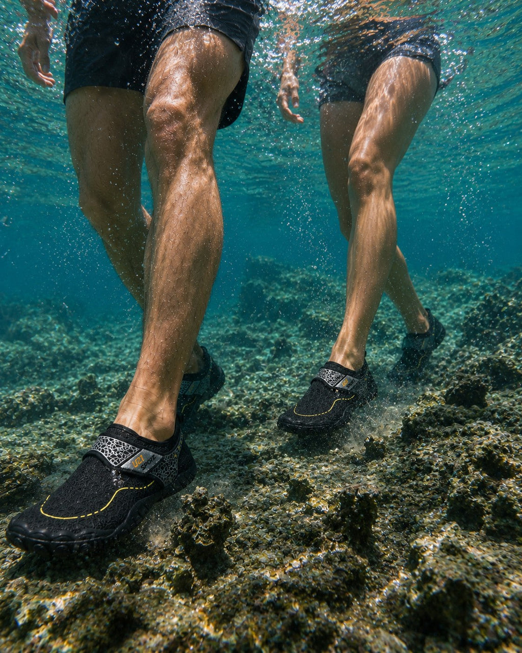 Personas caminando bajo el agua con zapatos acuáticos Manta Flow Black de uzi sport guadalajara sobre rocas marinas