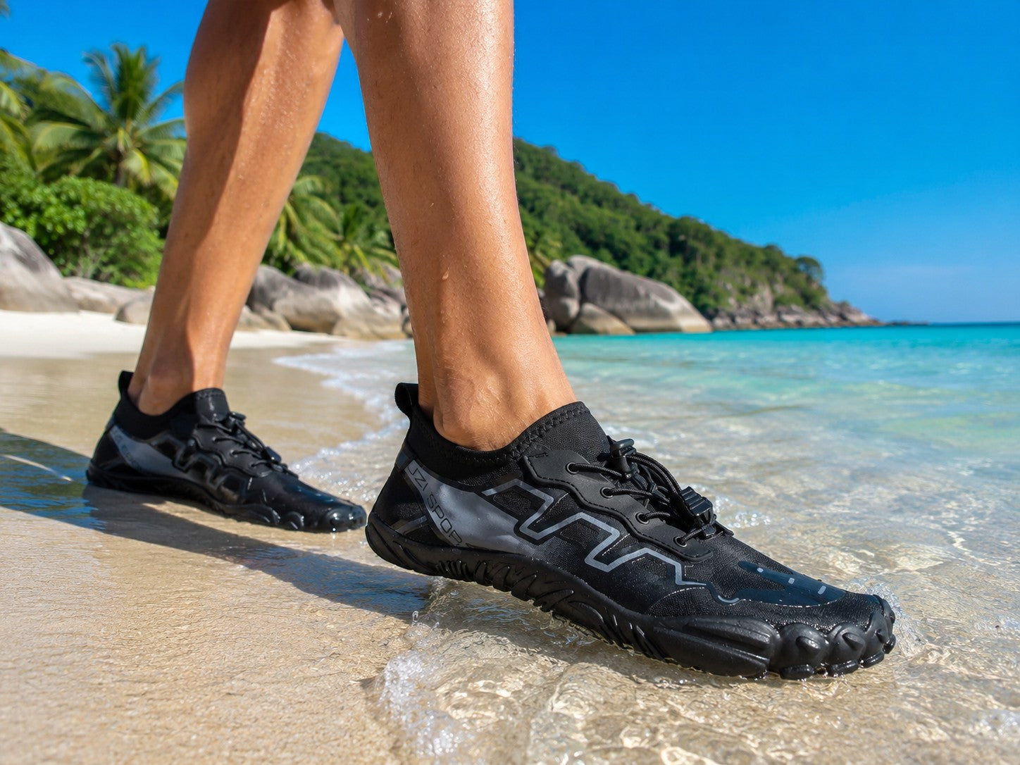 Zapato acuático uzi sport guadalajara modelo Black Beach negro con suela de agarre en una playa tropical