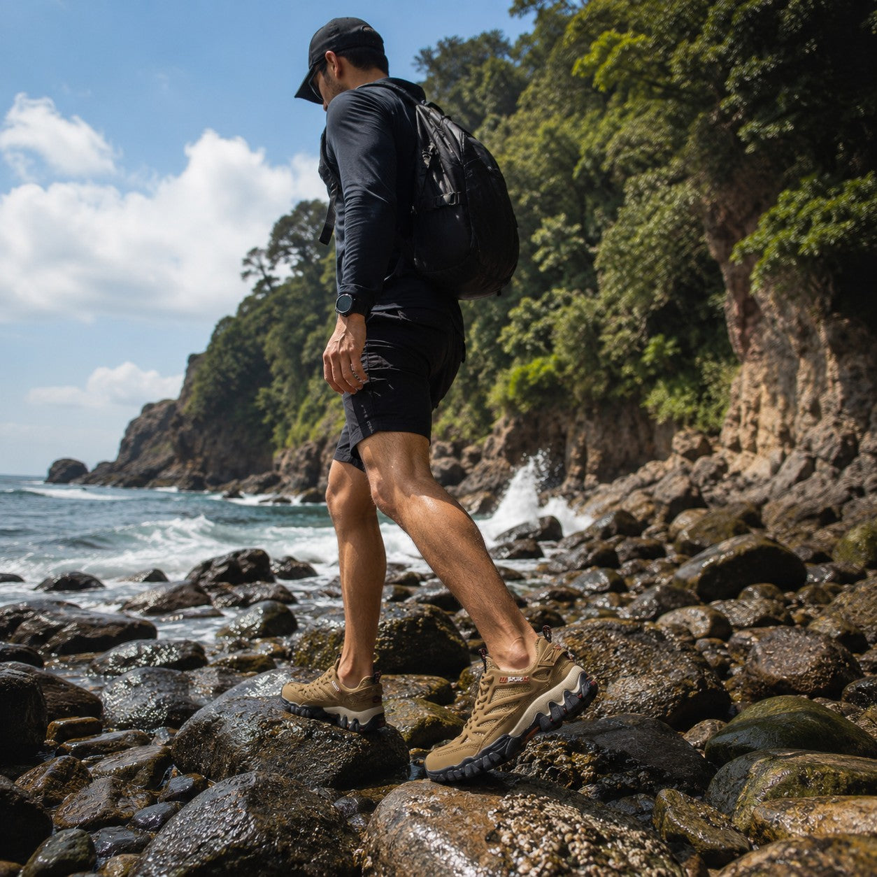 Hombre caminando sobre rocas costeras con zapatos outdoor uzi sport guadalajara Nómada color beige y suela resistente