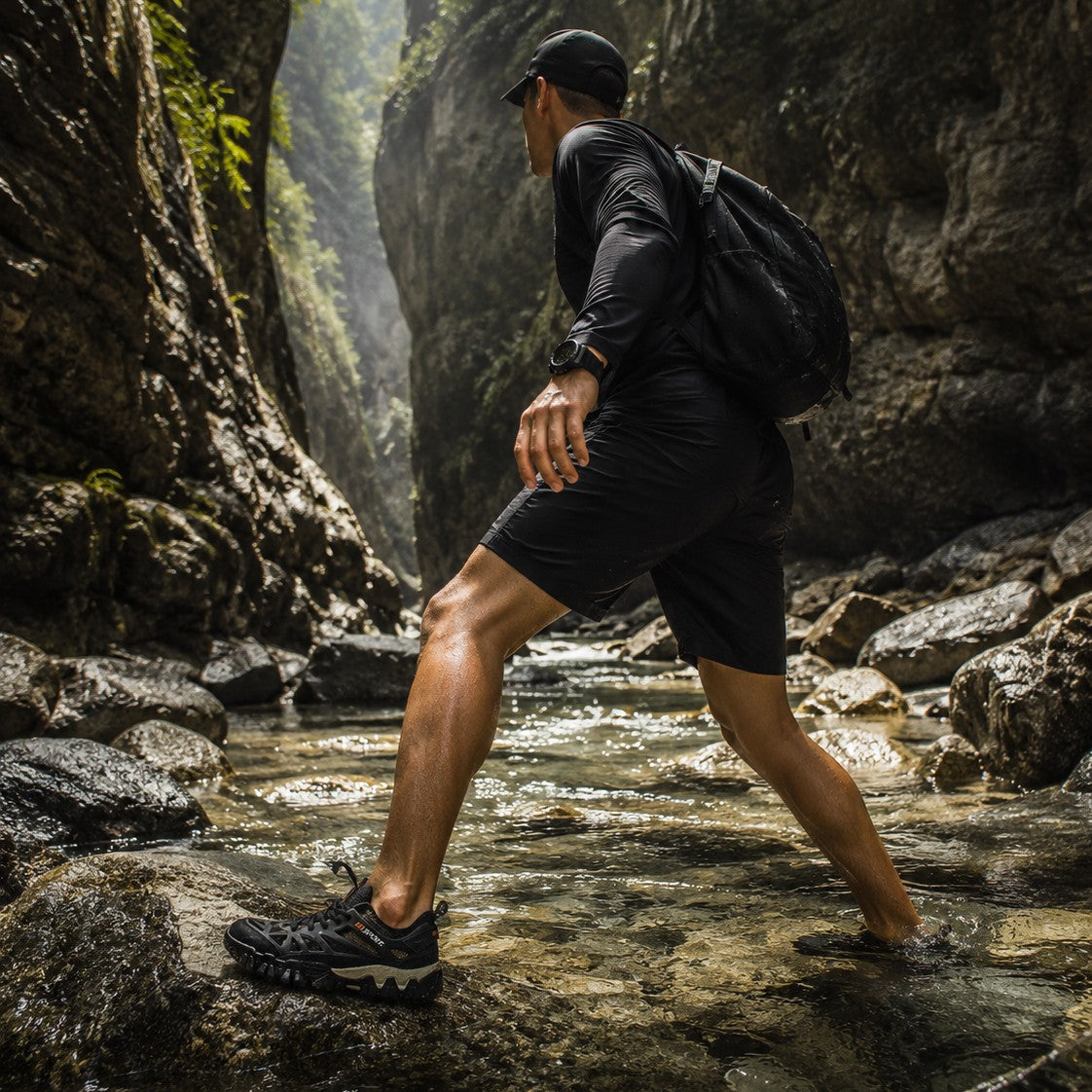 Hombre con calzado uzi sport guadalajara Nómada caminando sobre rocas en un río, ideal para senderismo y aventura.