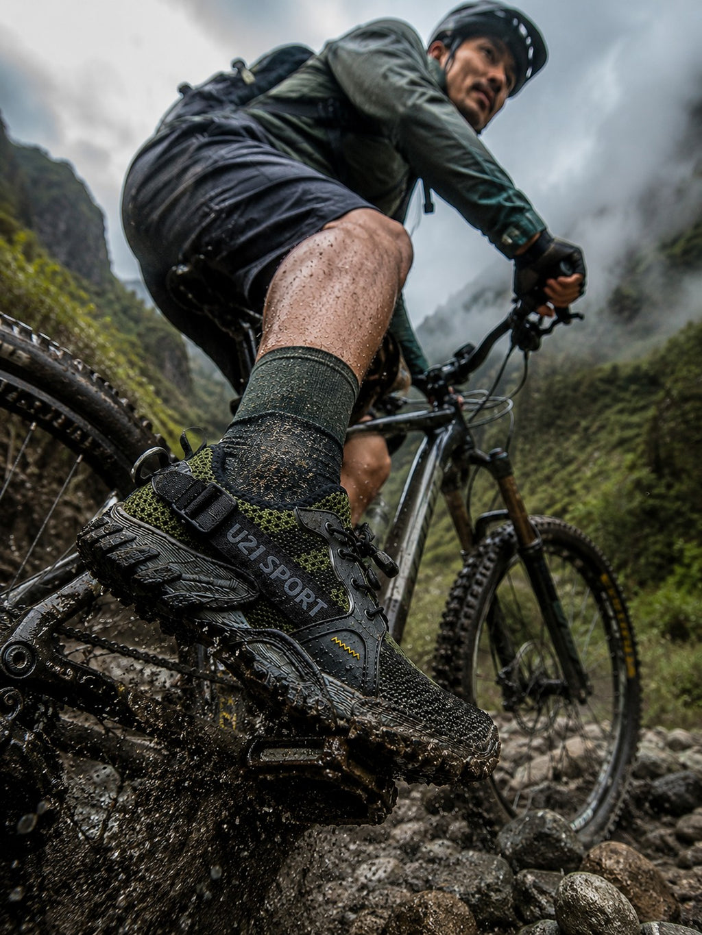 Ciclista usando zapatos de senderismo uzi sport guadalajara Master Trekker verdes con suela dentada en terreno rocoso