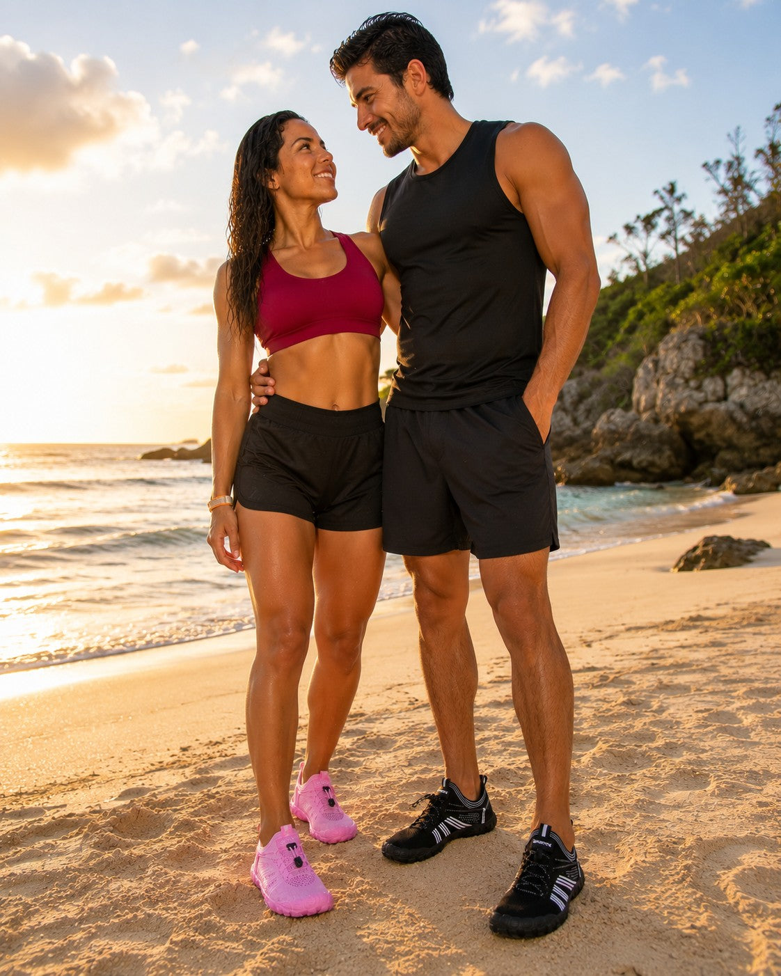Pareja en la playa usando zapatos acuáticos uzi sport guadalajara, modelos en rosa y negro para senderismo en ríos.