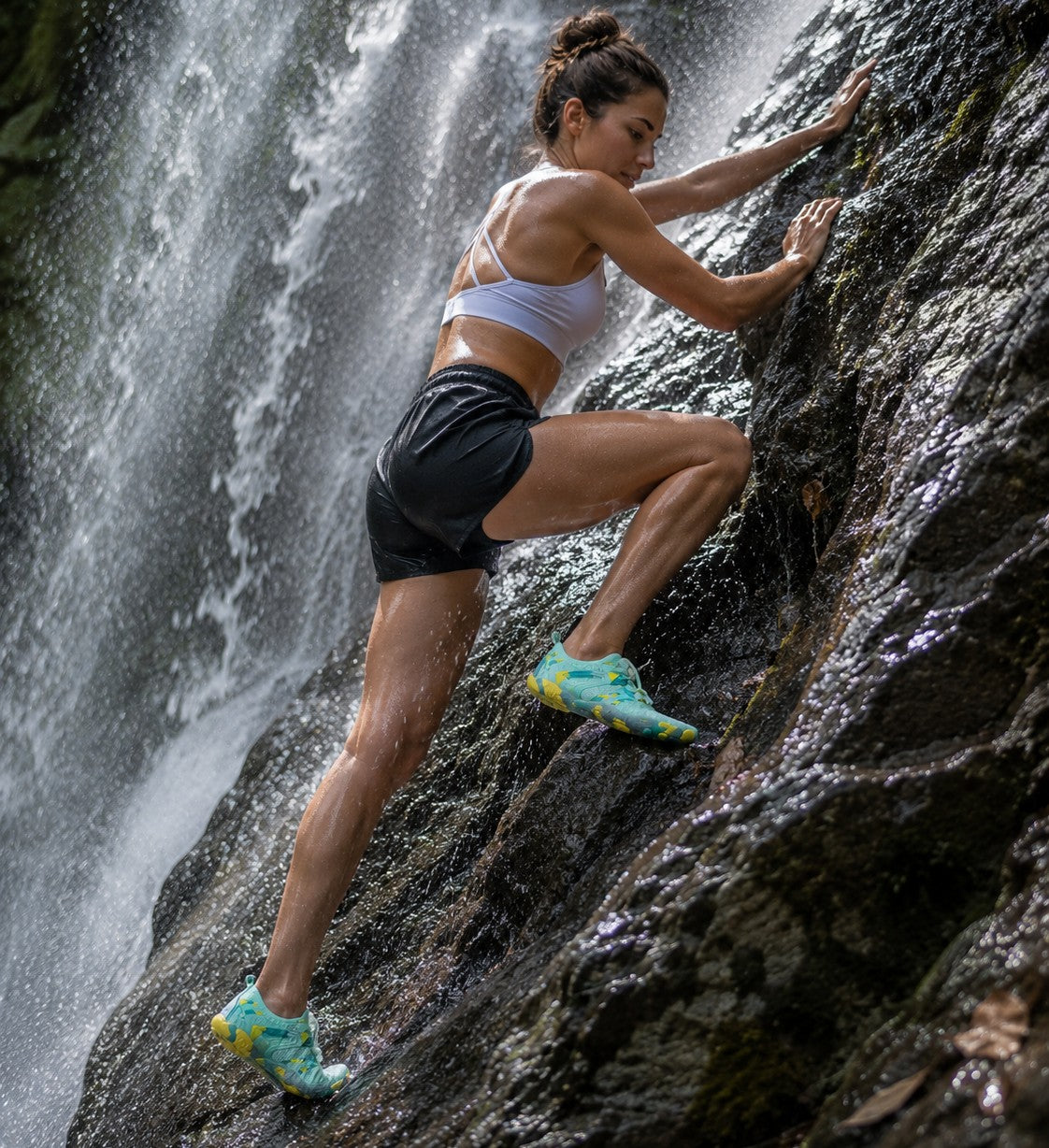 Mujer escalando una roca húmeda junto a una cascada usando zapatos de agua uzi sport guadalajara Octopus Aqua turquesa